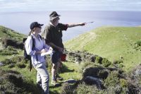 Banks Peninsula Conservation Trust Wildside Coordinator Marie Haley with local trapper John Stuart inspecting trap lines near the sooty shearwater enclosure at Stony Bay. Image - Les McNamara.