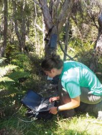 Sam Brown downloading data from a camera trap. Image - Bruce Warburton