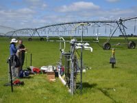 FIGURE 1 Measurement setup to determine greenhouse gas budgets of irrigated pasture. Intakes for gas sampling from two heights are on the taller mast on the right, recognisable by the yellow and blue tubes. Instruments to measure fast changes of wind and CO<sub>2</sub> concentration are mounted on the smaller mast, rear left. Other visible instruments record radiation, temperature, humidity, and wind. (Photo: John Hunt) 