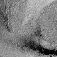 Subscene of RADARSAT standard beam data showing wind, wind shadow, wave, and current structures in the sea off Cape Egmont, North Island, New Zealand. C.CSA 1999.