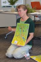 Educator Robinne Wiess with snakes-and-ladders game to teach about the highs and lows of biocontrol evaluation