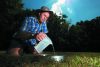 Soil scientist Sam Carrick pours water into a defined area of soil to measure the absorption rate at Manaaki Whenua in Lincoln