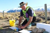 Dr Grant Norbury sets a tracking tunnel to monitor predator abundance.