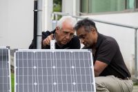 Jagath Ekanayake and Bruce Warburton checking solar panels