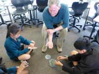 Hugh Gourlay and students examining biocontrol insects 