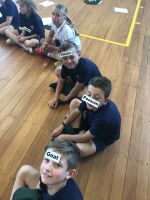 Paroa School students with plant and animal labels used in the ecological 'web-of-life' exercise. Photo: Rianna Farr, Paroa School